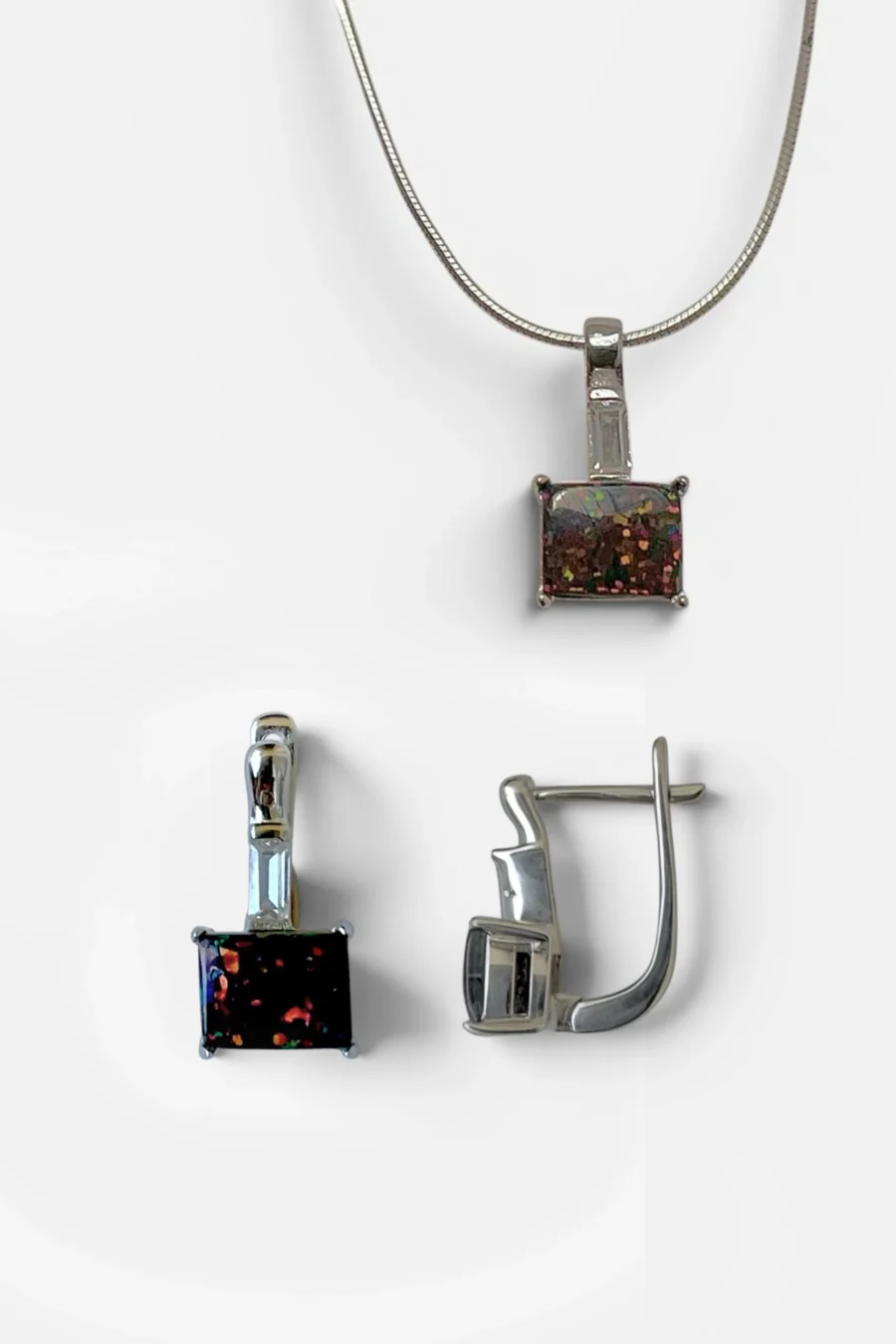 Silver necklace featuring a rectangular multicolor gemstone pendant on a slim chain, centered in view with white background